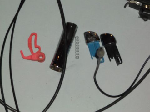 1999 Mercury Grand Marquis - Various car door lock components are laid out on a flat surface, including a lock cylinder and key fobs.