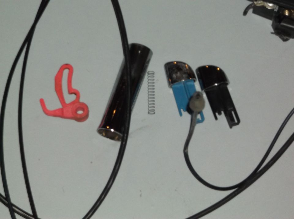 Car door lock cylinder, spring, and two plastic key fobs with a red plastic clip