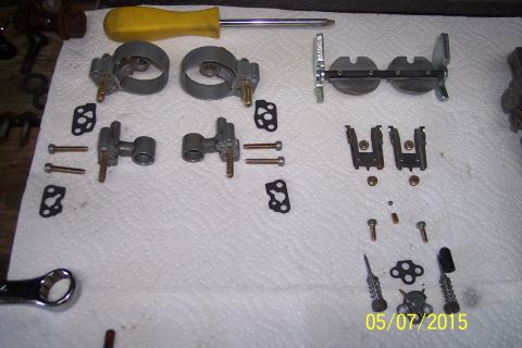 1973 Ford F-250 - Carburetor components and a screwdriver laid out for rebuilding, with a wrench visible at the bottom left.