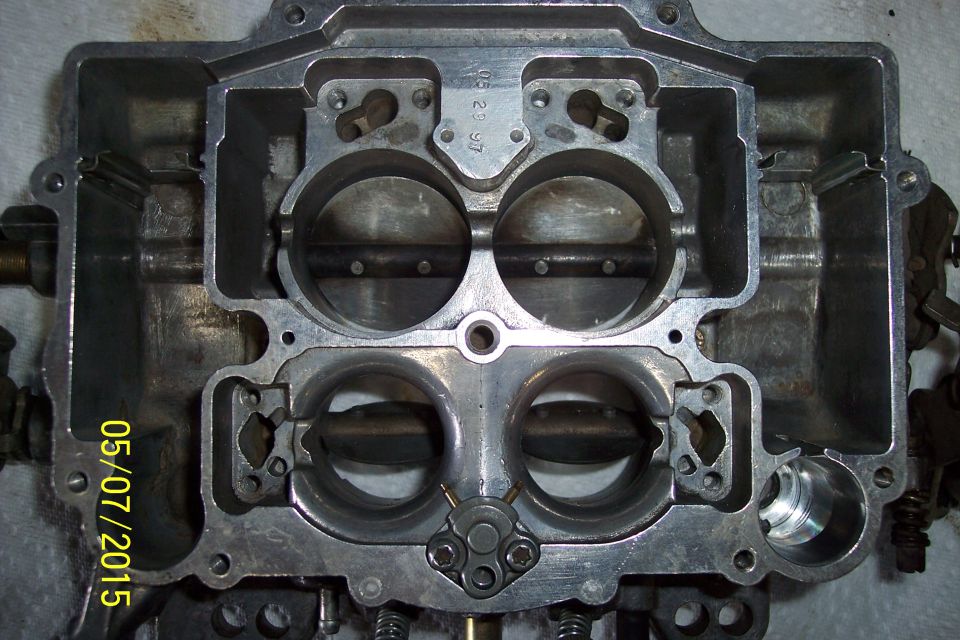 Carburetor with four throttle bores, showing internal components and date stamp
