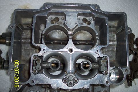 1973 Ford F-250 - Close-up of a carburetor's internal components, showing the four barrels and associated linkage mechanisms.