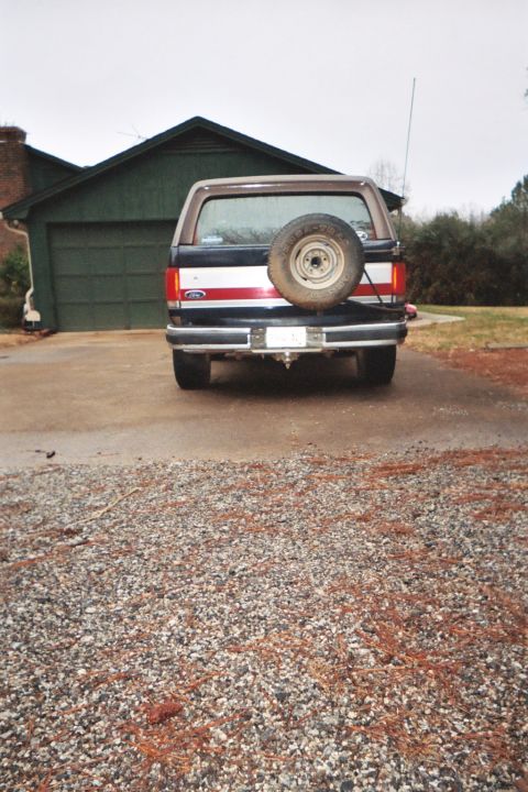 1988 Ford Bronco - The rear of a Ford Bronco is shown parked in front of a garage on a cloudy day.