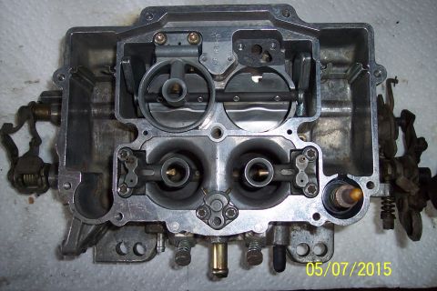 1973 Ford F-250 - Close-up of a disassembled carburetor, showing internal components and linkages.