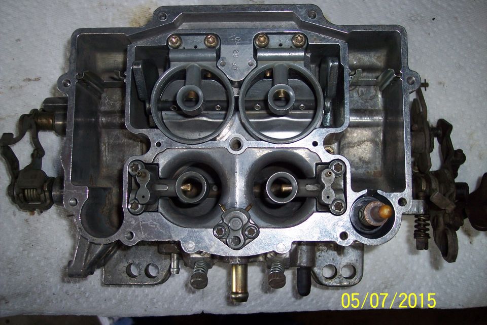 Carburetor with four barrels and visible linkage, top view