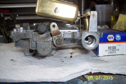 1973 Ford F-250 - Close-up of a carburetor assembly, a brass float and a NAPA RS1034 switch/commutator interruptor box in the background.