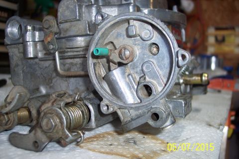 1973 Ford F-250 - A carburetor sits on a paper towel, showing its internal mechanisms and external linkages.