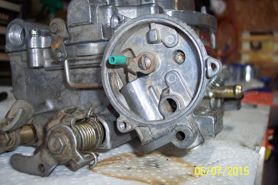 Close-up of a carburetor with linkage and springs visible