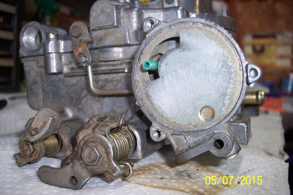 Carburetor with linkage visible, showing wear and some grime