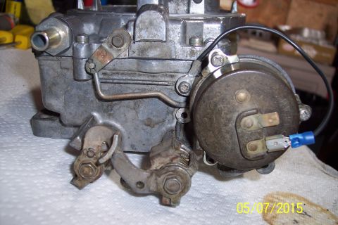 1973 Ford F-250 - A carburetor sits on a white cloth, showing mechanical and electrical components.
