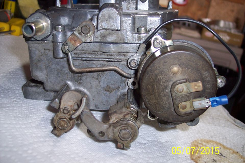 Close-up of a carburetor with linkage and electrical connections