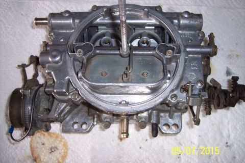 1973 Ford F-250 - A detailed view of a carburetor, showing its internal mechanisms and external fittings.