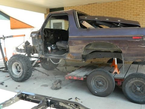 1979 Ford Bronco - Ford Bronco undergoing repairs, with its doors removed and body on a trailer.