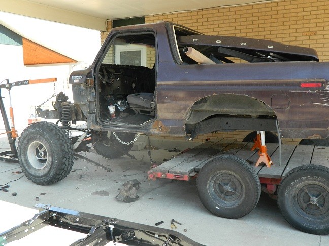 1978 Ford Bronco with doors removed, being worked on, sitting on a trailer