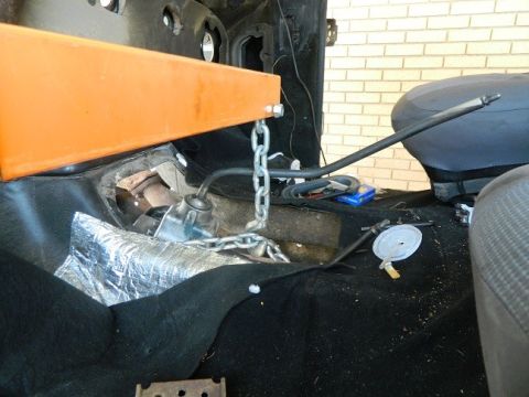 1979 Ford Bronco - Interior view of a vehicle with an engine hoist chain connected, suggesting maintenance or repair work.