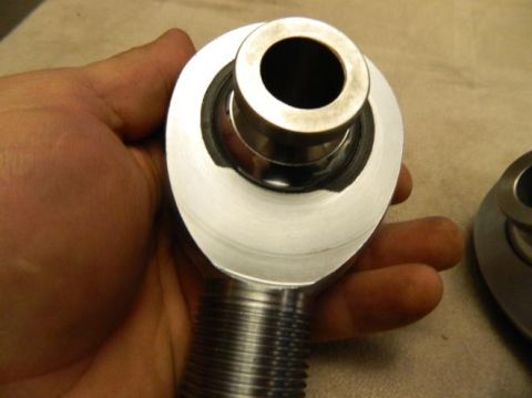 1979 Ford Bronco - Close-up of a rod end bearing part being held by a hand.