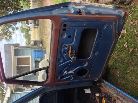 1979 Ford Bronco - The interior of a blue vehicle door, showing rust and exposed mechanical components.