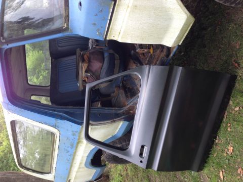 1979 Ford Bronco - The interior of a dilapidated blue and white Ford Bronco shows worn seats and missing parts.