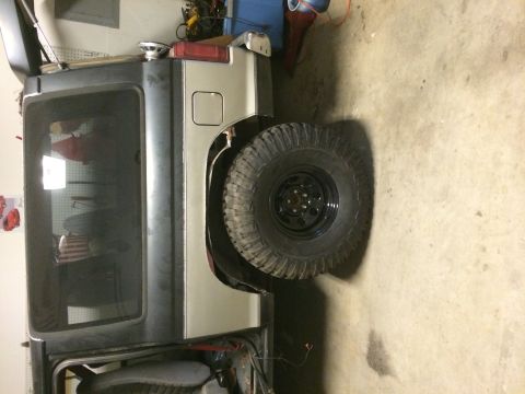 1988 Ford Bronco II - The rear quarter panel and spare tire of an SUV are visible in this garage setting.