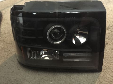 1996 Ford Bronco - This is a single aftermarket truck headlight assembly with a projector lens and halo ring.
