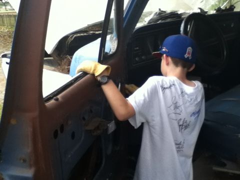 1979 Ford Bronco - Interior view of a vehicle undergoing restoration, with a young person cleaning.