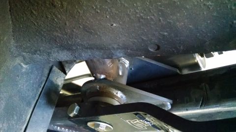 1985 Jeep CJ7 - A close-up view of a vehicle's suspension system, showing metal brackets and bolts.