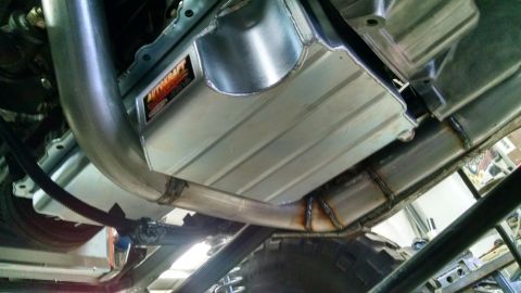 1985 Jeep CJ7 - Aftermarket exhaust and oil pan installed on a vehicle's undercarriage.