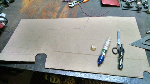 1985 Jeep CJ7 - A cardboard template is laid out on a workbench with tools, suggesting a custom part is being fabricated.
