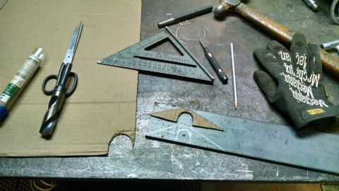 1985 Jeep CJ7 - A workbench is laid out with various tools including a drill bit modified into scissors, a speed square, and metal pieces ready for fabrica…