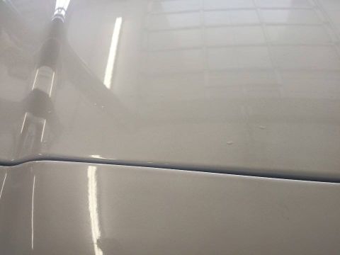 2000 Mercury Grand Marquis - Close-up of the hood seam on a white 2000 Mercury Grand Marquis.