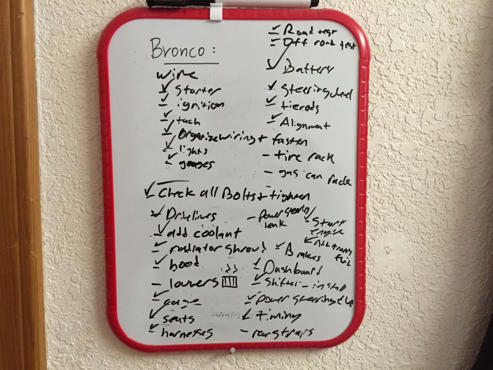 Whiteboard to-do list labeled Bronco with handwritten restoration tasks and checkmarks