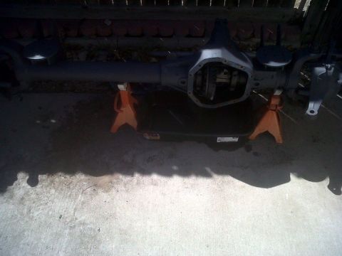 1979 Ford Bronco - A rear axle assembly is supported by orange jack stands on a concrete surface.