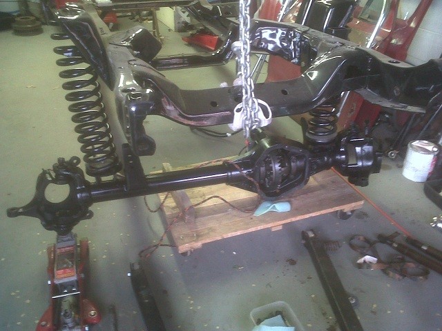 Vehicle frame and rear axle assembly suspended by chains, with a jack supporting the front suspension