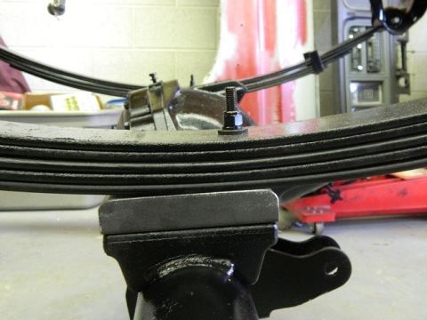 1979 Ford Bronco - Close-up of a vehicle's leaf spring assembly, likely undergoing maintenance or repair.