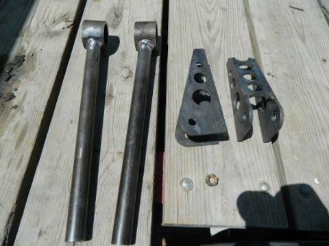 1979 Ford Bronco - Metal suspension parts are laid out on a wooden surface, with a watermark for Supermotors.net visible.