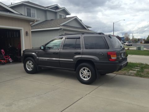 2004 Jeep Grand Cherokee - A dark gray 2004 Jeep Grand Cherokee is parked in a driveway on a cloudy day.
