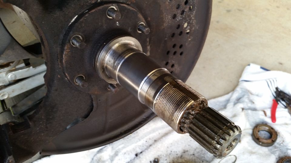 Vehicle axle with splines and brake rotor assembly on a white towel