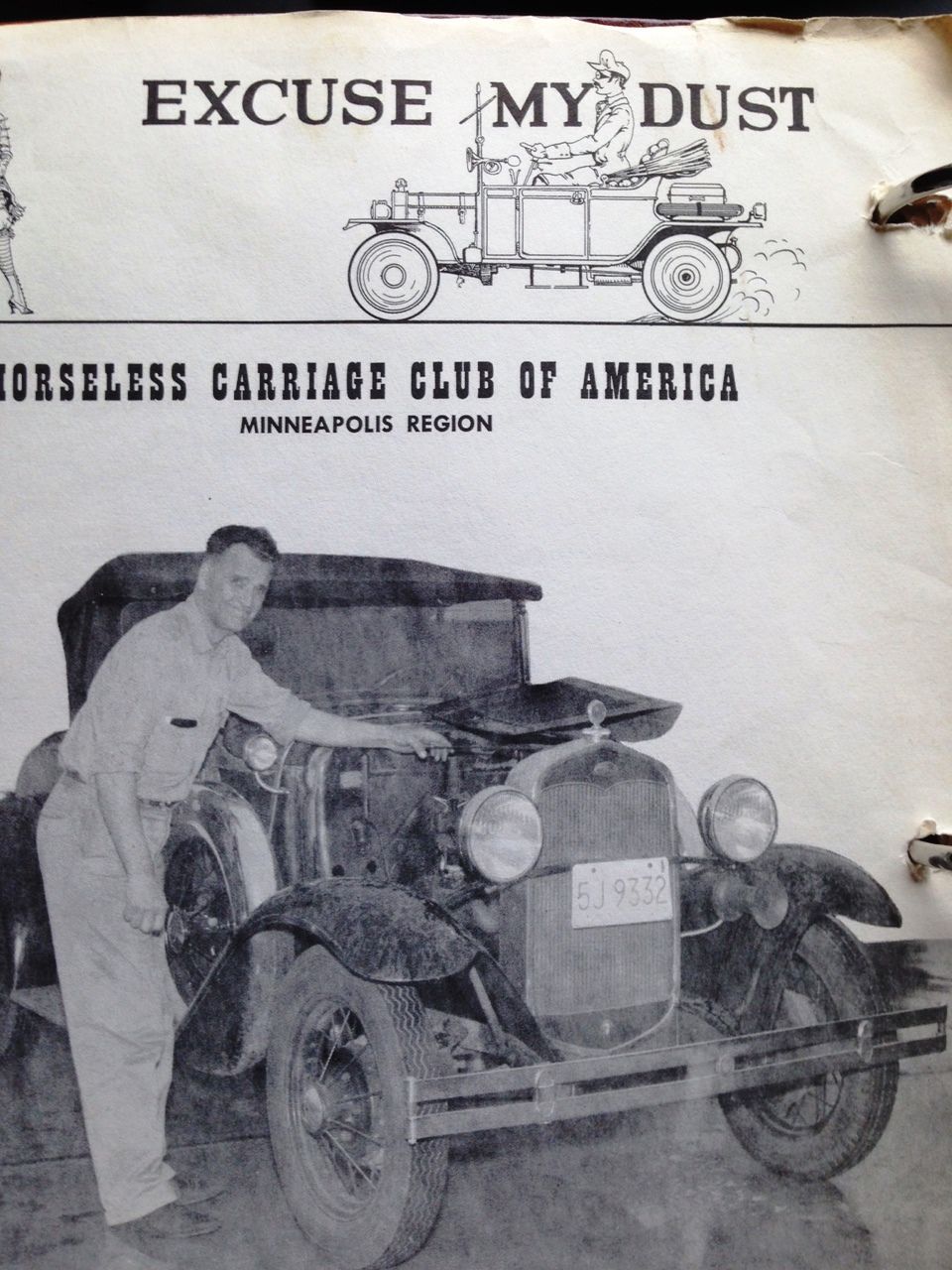 Front view of a 1928 Ford Model A with open hood and man beside it