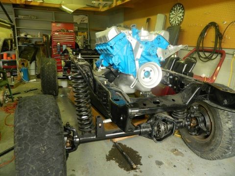 1979 Ford Bronco - Vehicle frame and engine assembly in a garage setting.