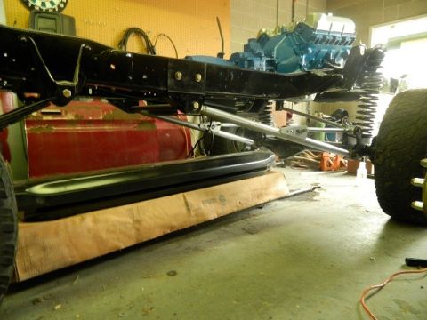 1979 Ford Bronco - The chassis and engine of a vehicle are visible, undergoing some form of work or assembly.
