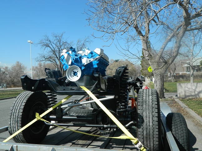 Vehicle chassis and blue/white engine on trailer