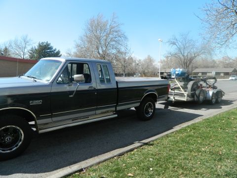 1979 Ford Bronco - Ford F-250 pickup truck with a trailer is parked on the side of the road.