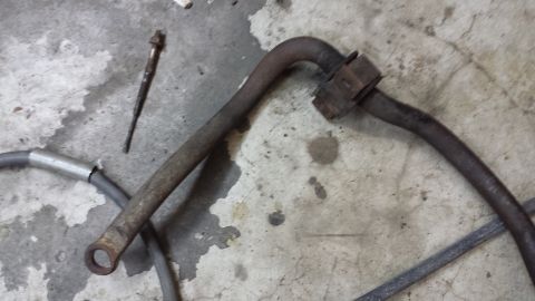 1978 Ford Bronco - Two old metal automotive parts lie on a stained concrete surface.