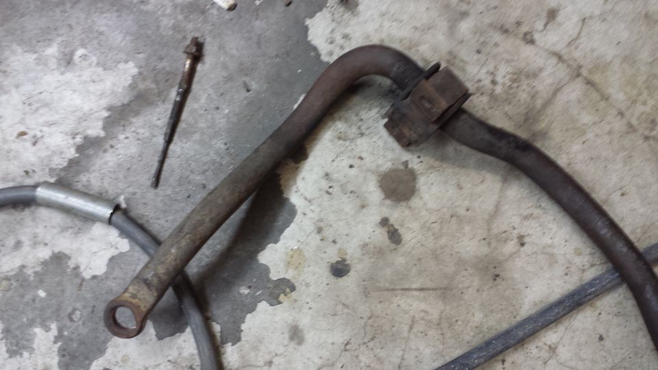 rusted metal bar and a bolt on a concrete floor