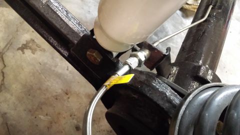 1978 Ford Bronco - Close-up view of brake fluid reservoir and lines connected to a vehicle's frame.