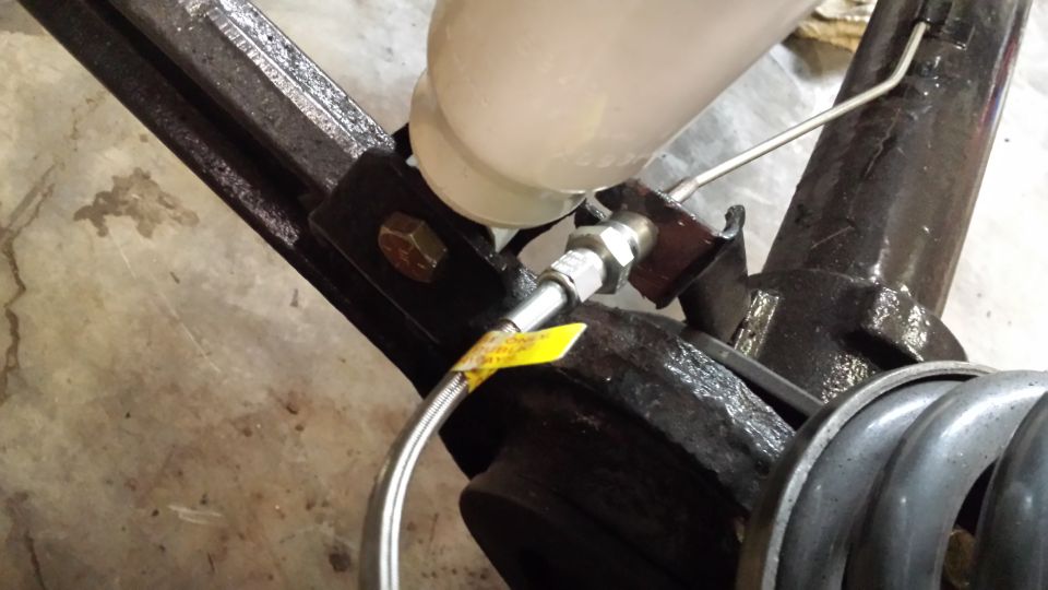 Brake fluid reservoir and lines attached to metal frame