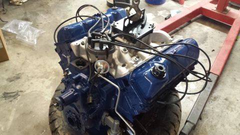 1978 Ford Bronco - A freshly painted Ford V8 engine sits on a red engine stand, ready for installation.