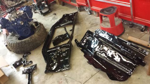 1978 Ford Bronco - Engine and body parts are laid out on a workshop floor, suggesting a restoration project.