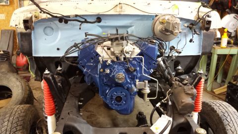 1978 Ford Bronco - Engine bay during restoration, with a freshly painted blue engine and suspension parts visible.
