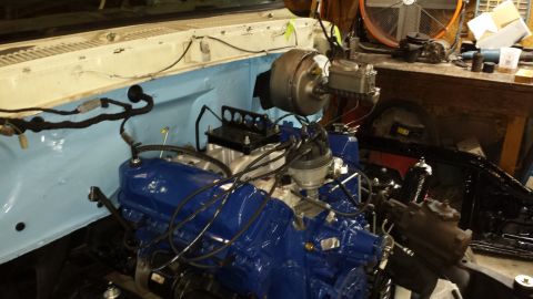 1978 Ford Bronco - The engine bay of a vehicle is shown with a freshly painted blue engine and associated components.