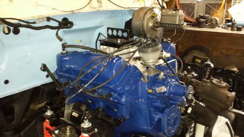 1978 Ford Bronco - Engine bay view of a blue V8 engine, likely undergoing restoration or repair.
